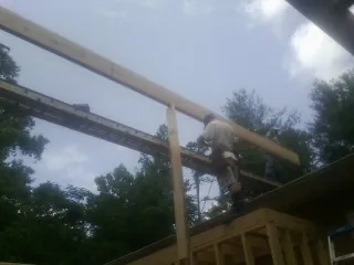 Carpenter setting a ridge beam over a new addition frame — Ice Dam Removal by Roofing Brothers in Keansburg