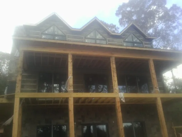 Dormers and porch framing on a large log home under construction — Roof Coating work by our crew in Keansburg