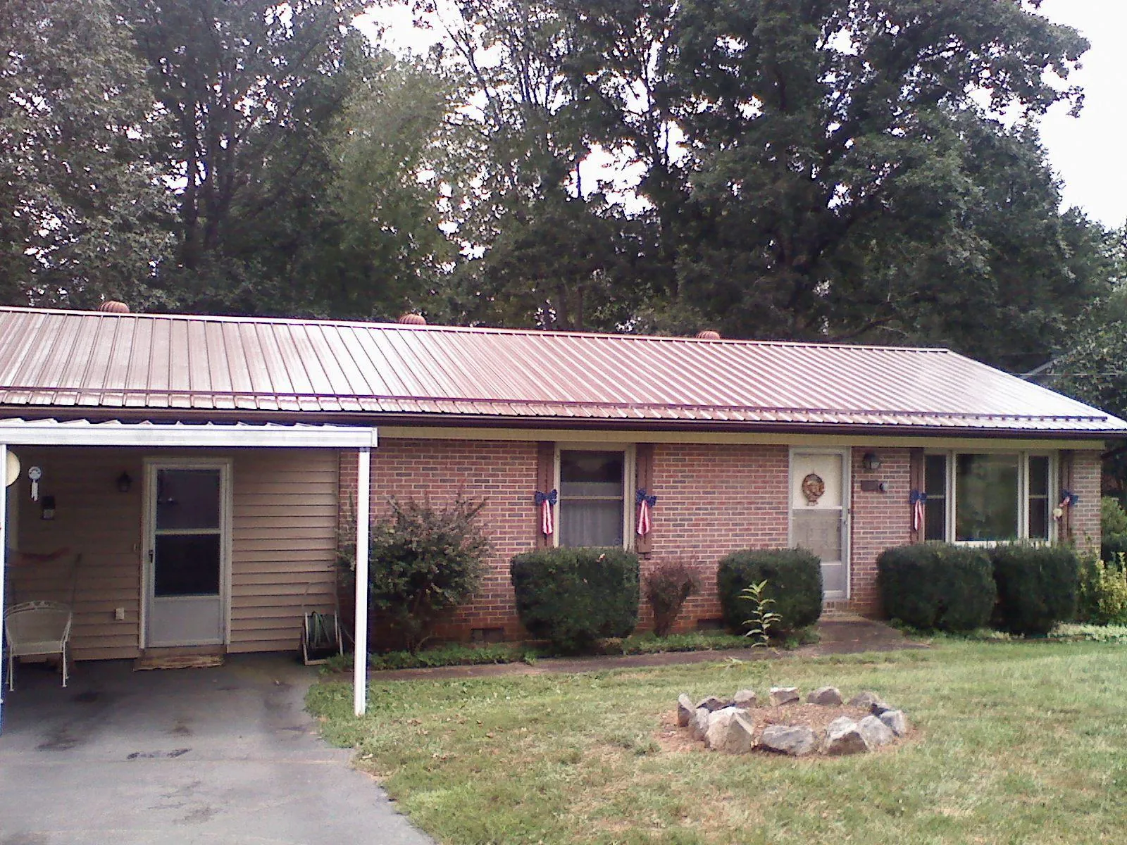 Bronze metal roof and carport on a brick ranch home — Roof Repair work by our crew in Keansburg
